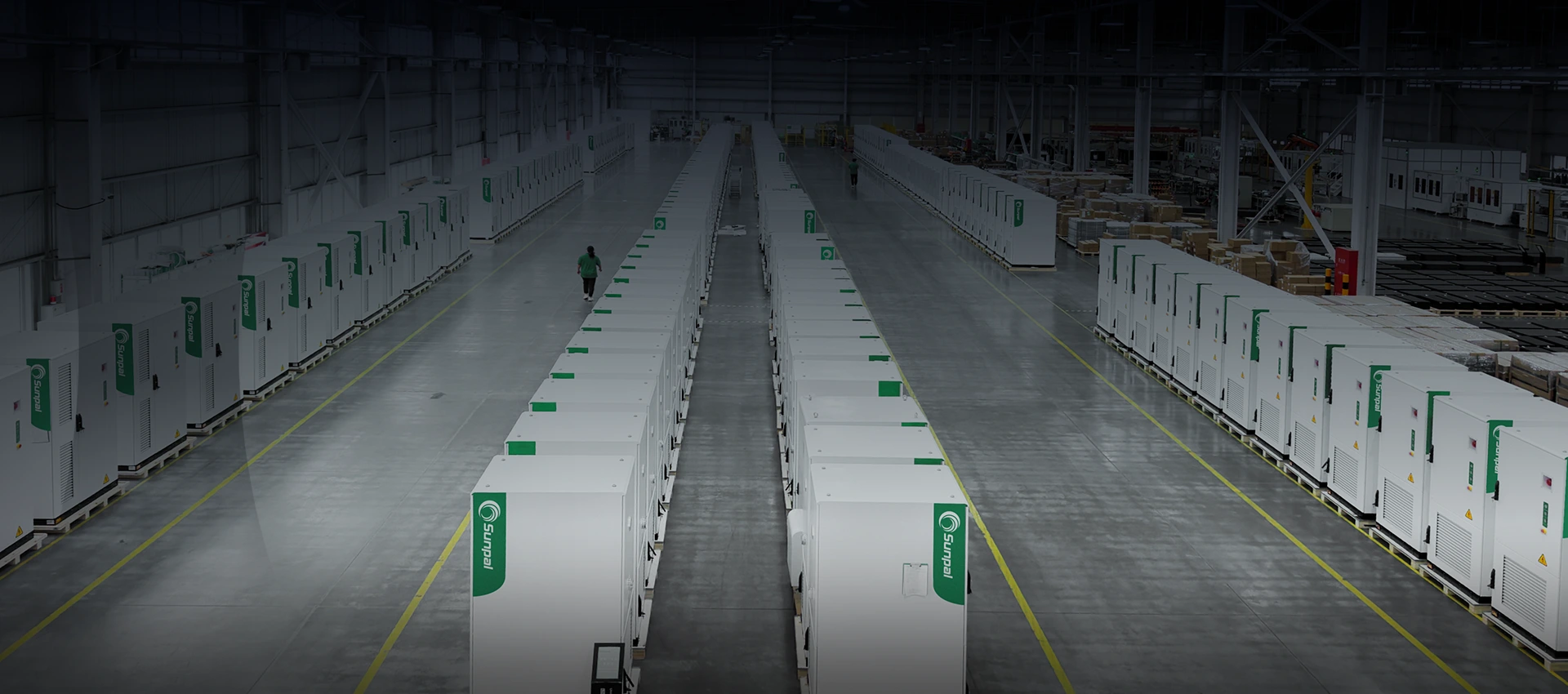 High-angle view of rows of assembled white Sunpal energy storage cabinets inside a spacious manufacturing warehouse.
