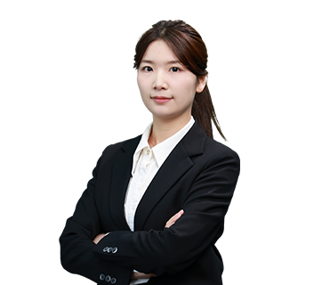 Professional portrait of Sales Director Angelia Zhang standing with arms crossed, wearing a black blazer and white shirt against a plain white background.