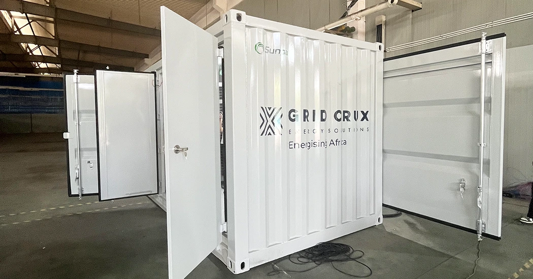 White energy storage container with Sunpal branding and open side doors inside a manufacturing facility.