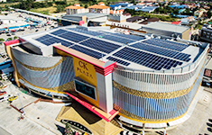 Aerial view of a commercial plaza building rooftop fully installed with rooftop solar panels for commercial energy storage.