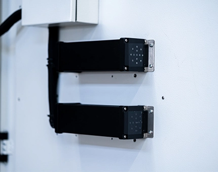 Dual aerosol fire suppression units mounted internally on the side wall of an energy storage cabinet with wiring connections.