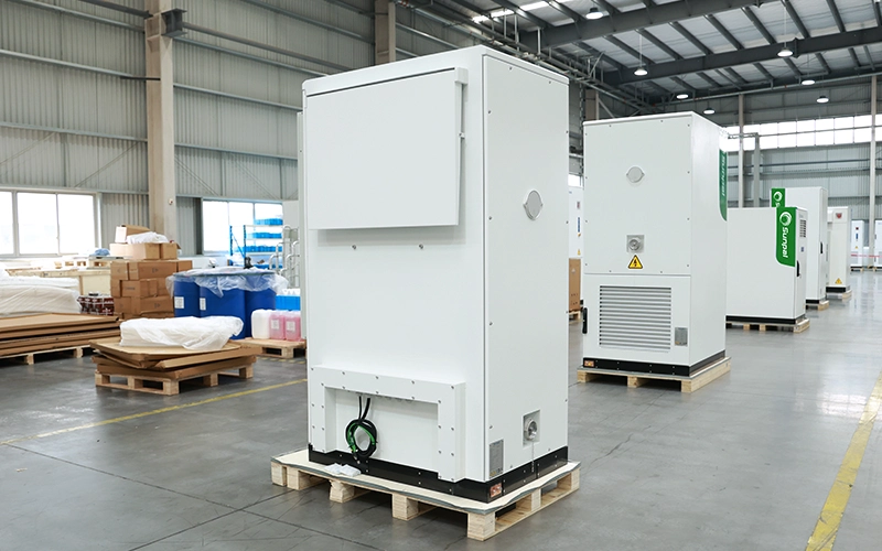 Rear view of the Sunpal ECO-B100-120WP-2H energy storage cabinet showing ventilation panels, grounding connections, and cable entry points in a factory setting.
