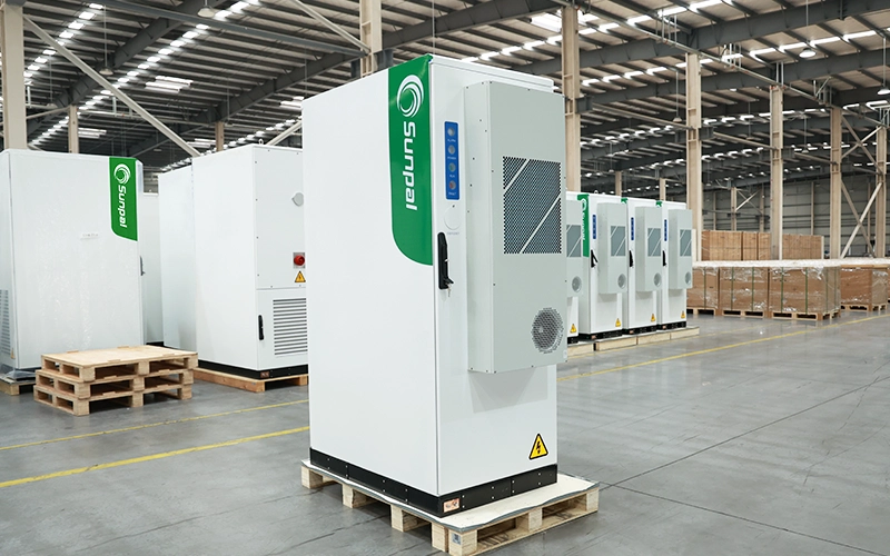 Front three-quarter view of the Sunpal ECO-B100-120WP-2H energy storage cabinet on a wooden pallet inside an industrial manufacturing factory.