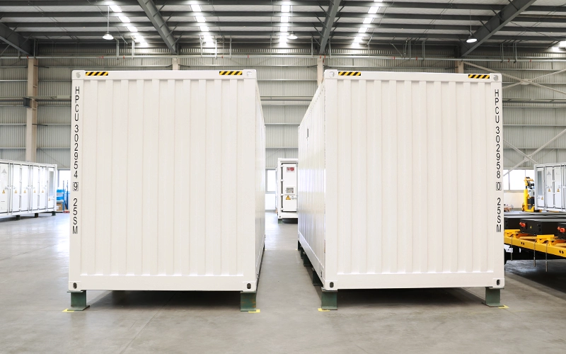 Right side exterior view of two white Sunpal 20-foot energy storage containers showing corrugated steel side panels inside a warehouse.
