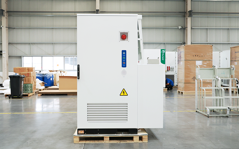 Front view of the white ECO-B261LP-2H energy storage cabinet with Sunpal branding, emergency stop button, control interface, and ventilation louvers inside a factory setting.