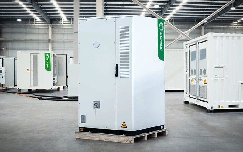 Rear view of a white Sunpal commercial energy storage cabinet on a wooden pallet inside a manufacturing facility, highlighting thermal management vents and fire protection ports.