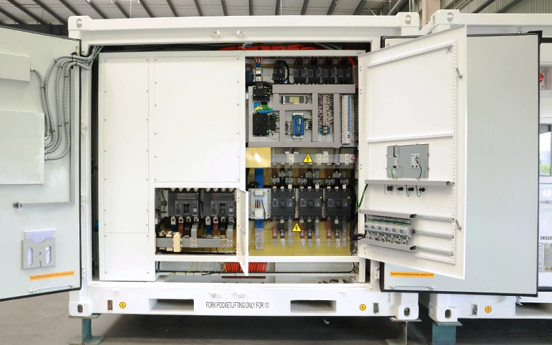 An open rear cabinet of a white energy storage container showcasing structured electrical distribution components, circuit breakers, terminal blocks, safety warning labels, and wiring management systems.