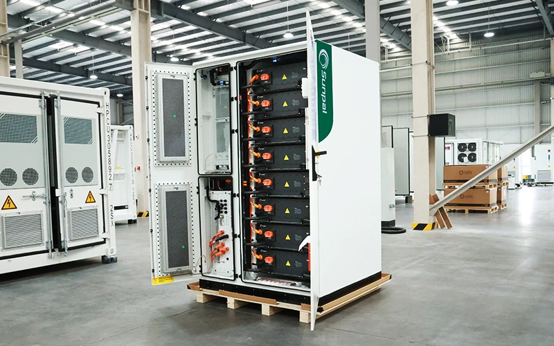 Open cabinet door revealing stacked high-voltage battery modules, internal wiring, and control electronics inside a Sunpal commercial energy storage unit.