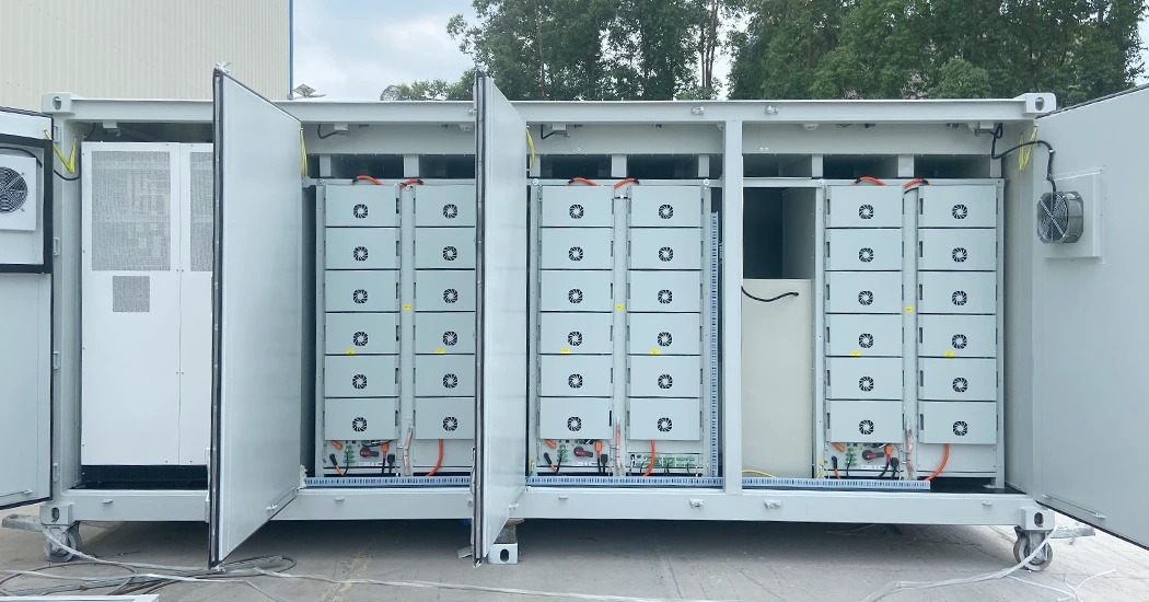 Front view of an open white battery storage container displaying neatly arranged battery racks and control modules.