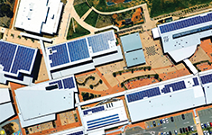 Aerial top-down view of a modern office parks with rooftop solar panels.