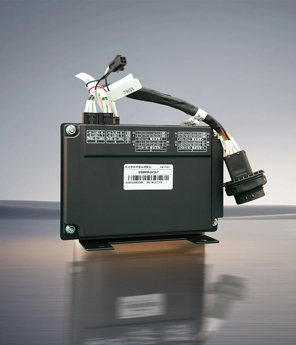 Pack-level battery management system control module standing upright with wiring harness attached on a reflective surface.