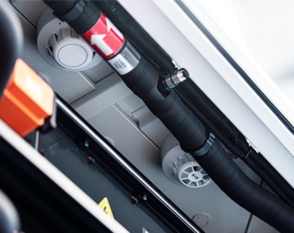 Ceiling-mounted smoke and heat sensors installed alongside insulated piping inside a battery energy storage cabinet.